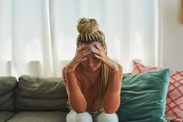 young woman looking sad on the sofa at home