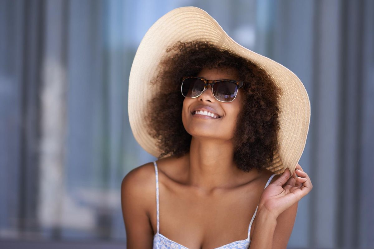 young woman wearing a sun hat relaxing outside